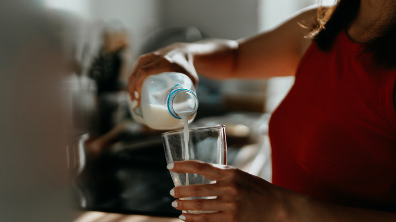 Woman pouring milk into a glass