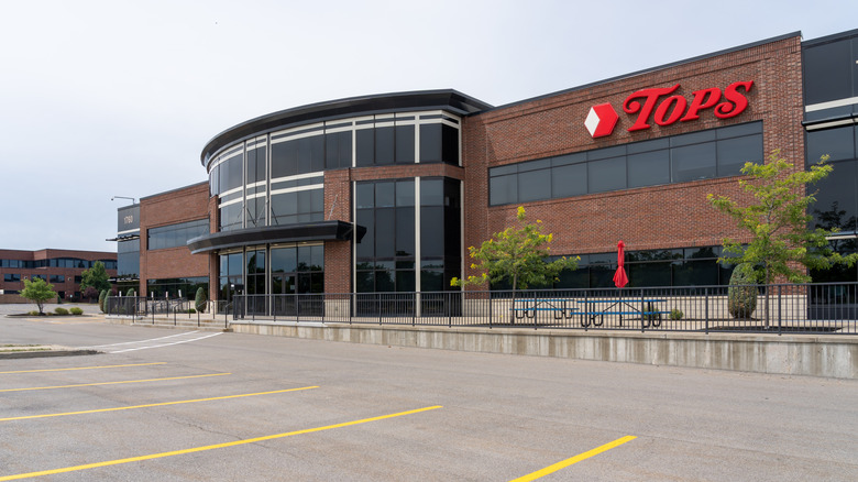 The front of a Tops Friendly Market, along with its parking lot.