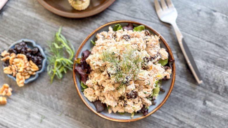 Triple anise chicken salad on serving plate with walnuts, cherries, and tarragon