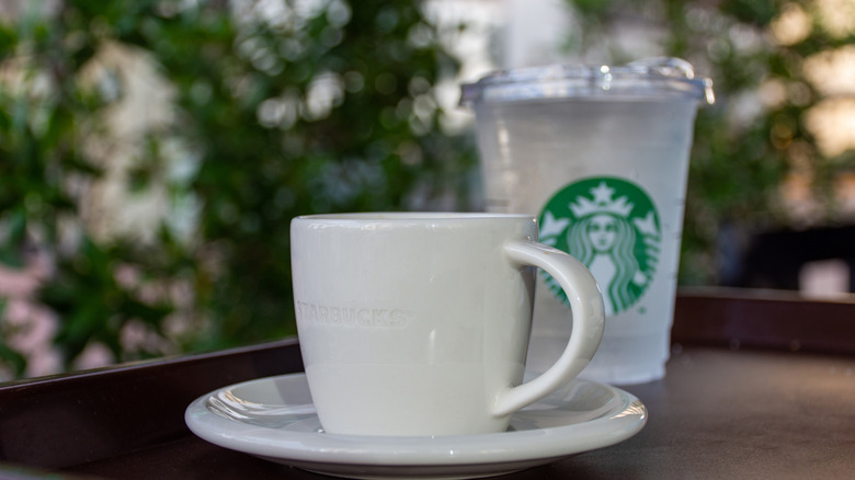 Cup of coffee and Starbucks water in foreground