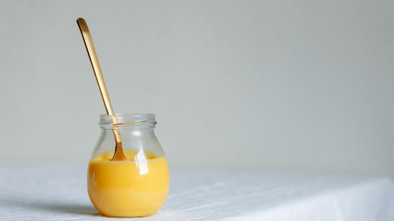 Lemon curd in a jar with a spoon