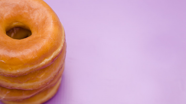 Purple background with stack of glazed donuts