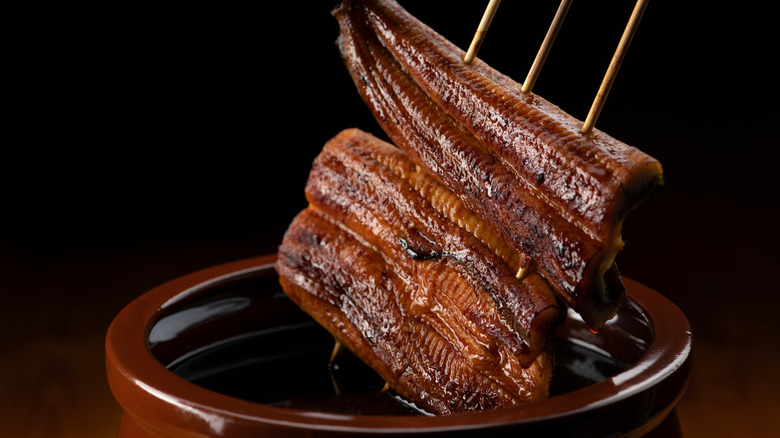 dipping eel into dark sauce