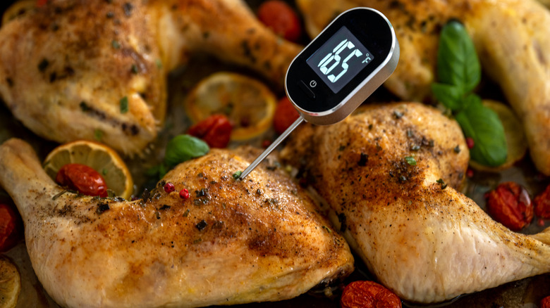 Close up of digital thermometer in chicken thigh