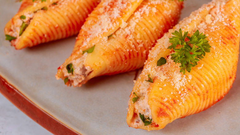 A close up of stuffed shells on a gray plate