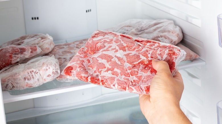 white hand with frozen meat