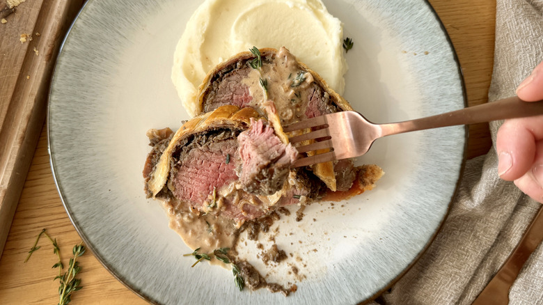 taking forkful of beef wellington
