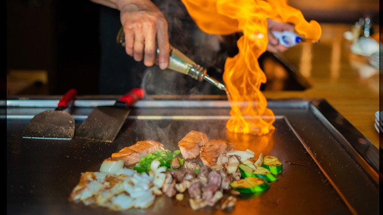 Meats and vegetables on a flaming hibachi grill