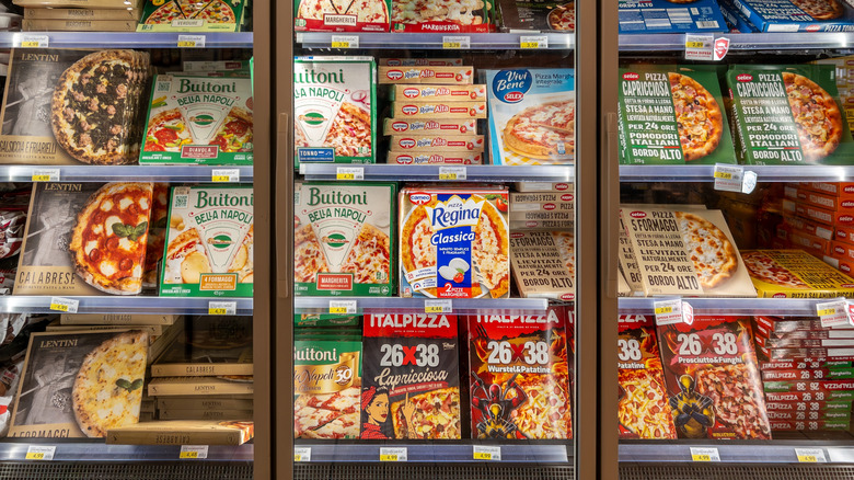 Frozen pizzas in the freezer aisle at a grocery store